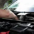 Mekanik sedang melakukan cara merawat mobil untuk perjalanan jauh di bengkel