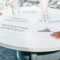 Tim profesional sedang merancang strategi pemasaran bisnis modern di papan tulis kantor