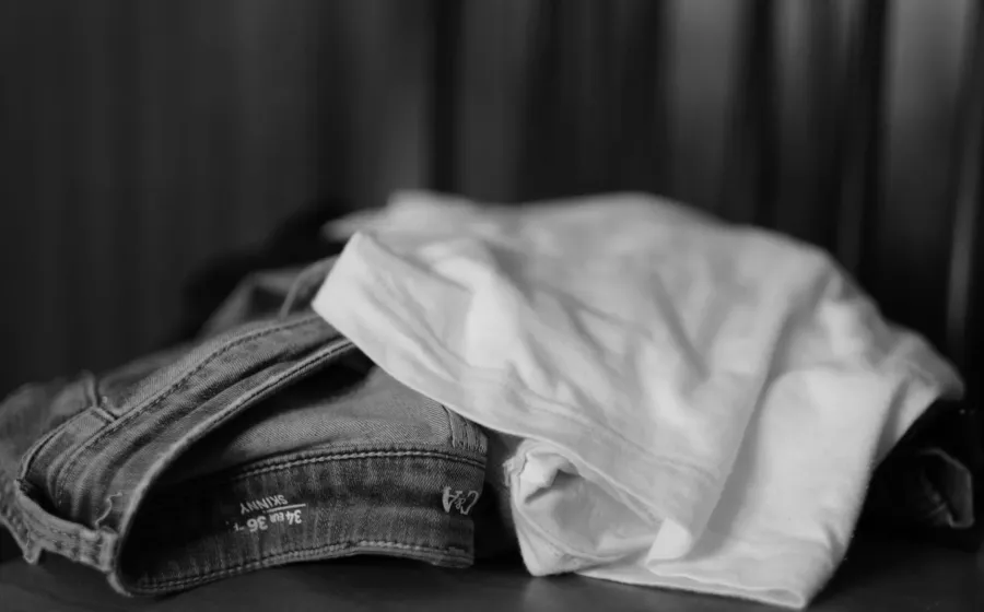 Pakaian nyaman berbahan katun dan linen yang tergantung rapi di gantungan baju kayu minimalis